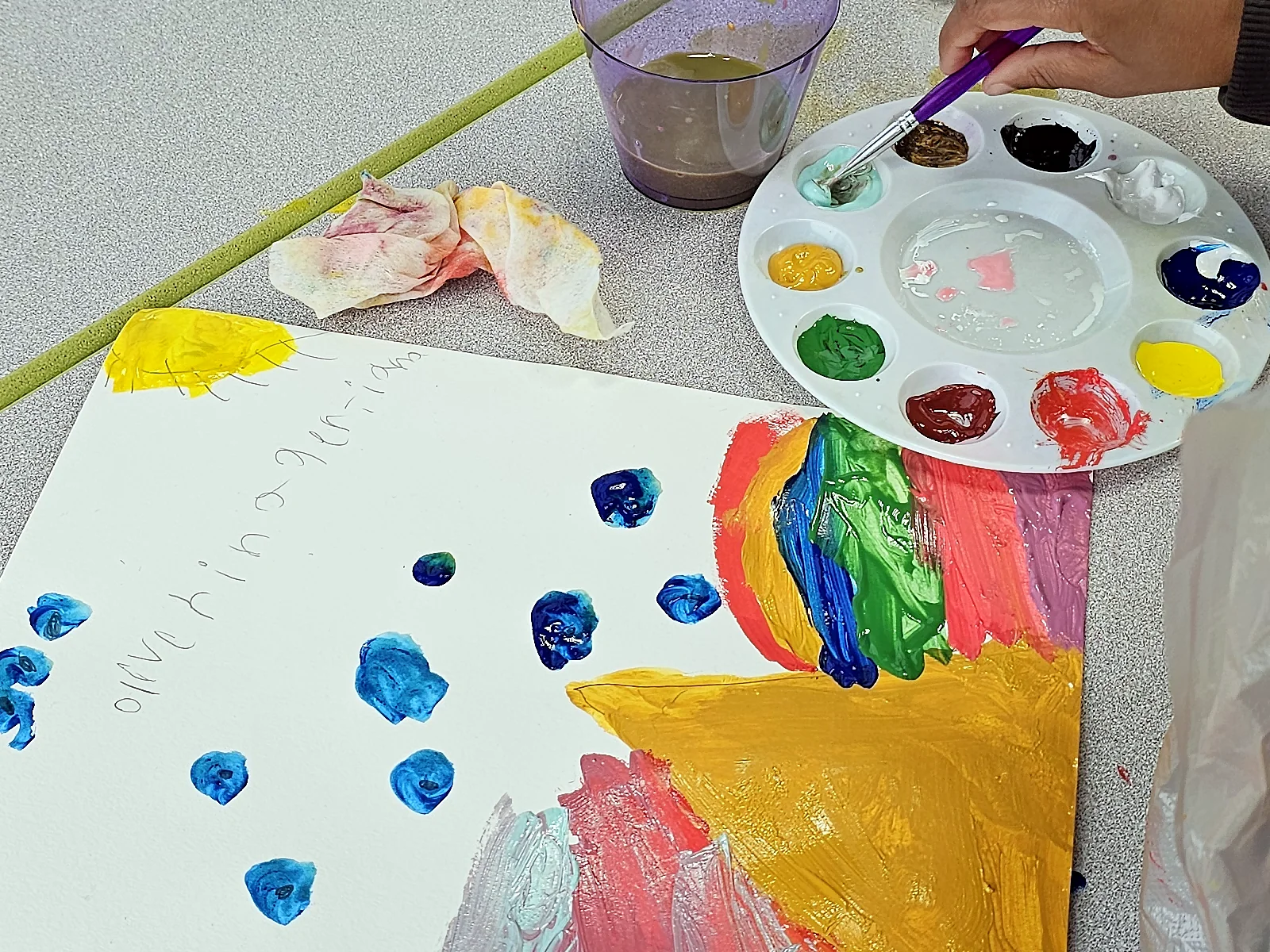 Obra infantil en proceso junto a una paleta de colores.